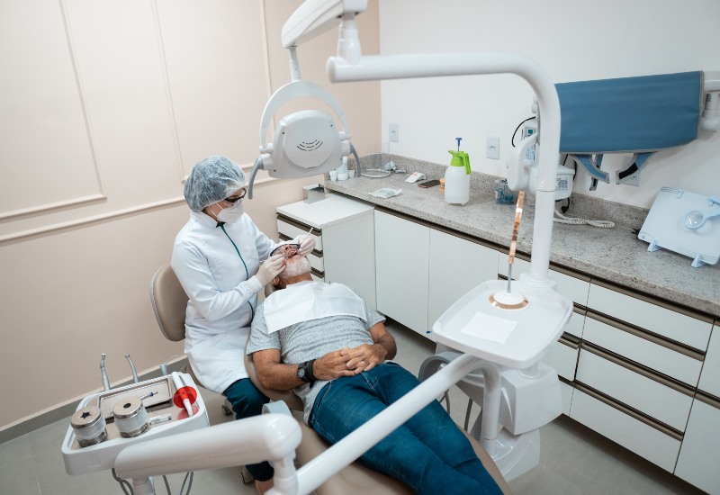 Dentist performing denture treatment in Trenton, MI