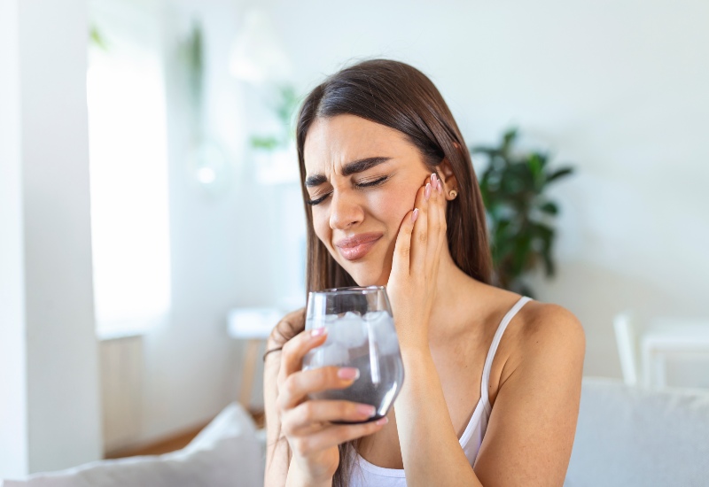 A patient in Trenton, MI experiencing symptoms of tooth sensitivity