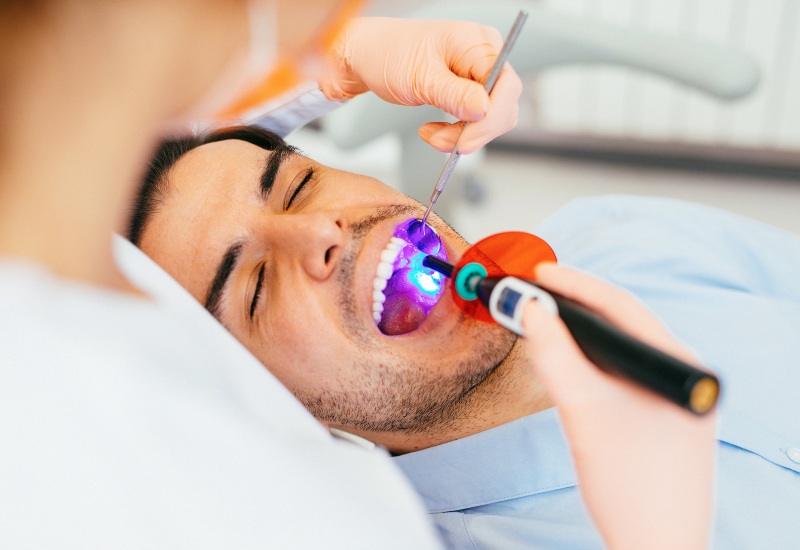 Dentist performing a restorative dental procedure with tools in Trenton, MI