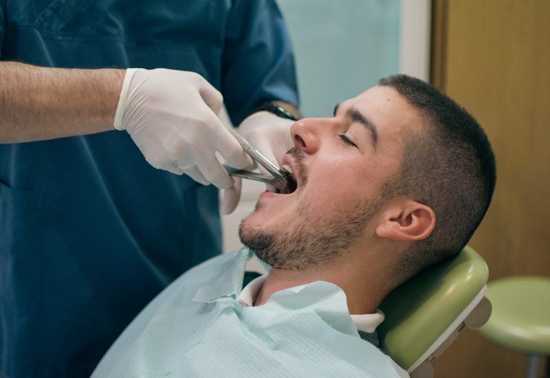 Dentist extracting tooth in Trenton, MI