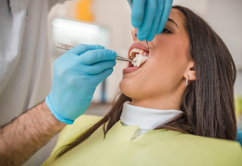 A dentist performing a careful tooth extraction procedure at a dental clinic in Trenton, MI