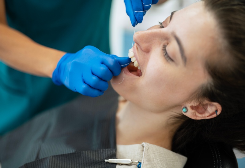 Proper flossing technique demonstrated during dental visit in Trenton, MI